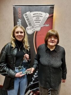 Ella Peebles being presented with the Allan Bruce Memorial Trophy by Marina Bruce